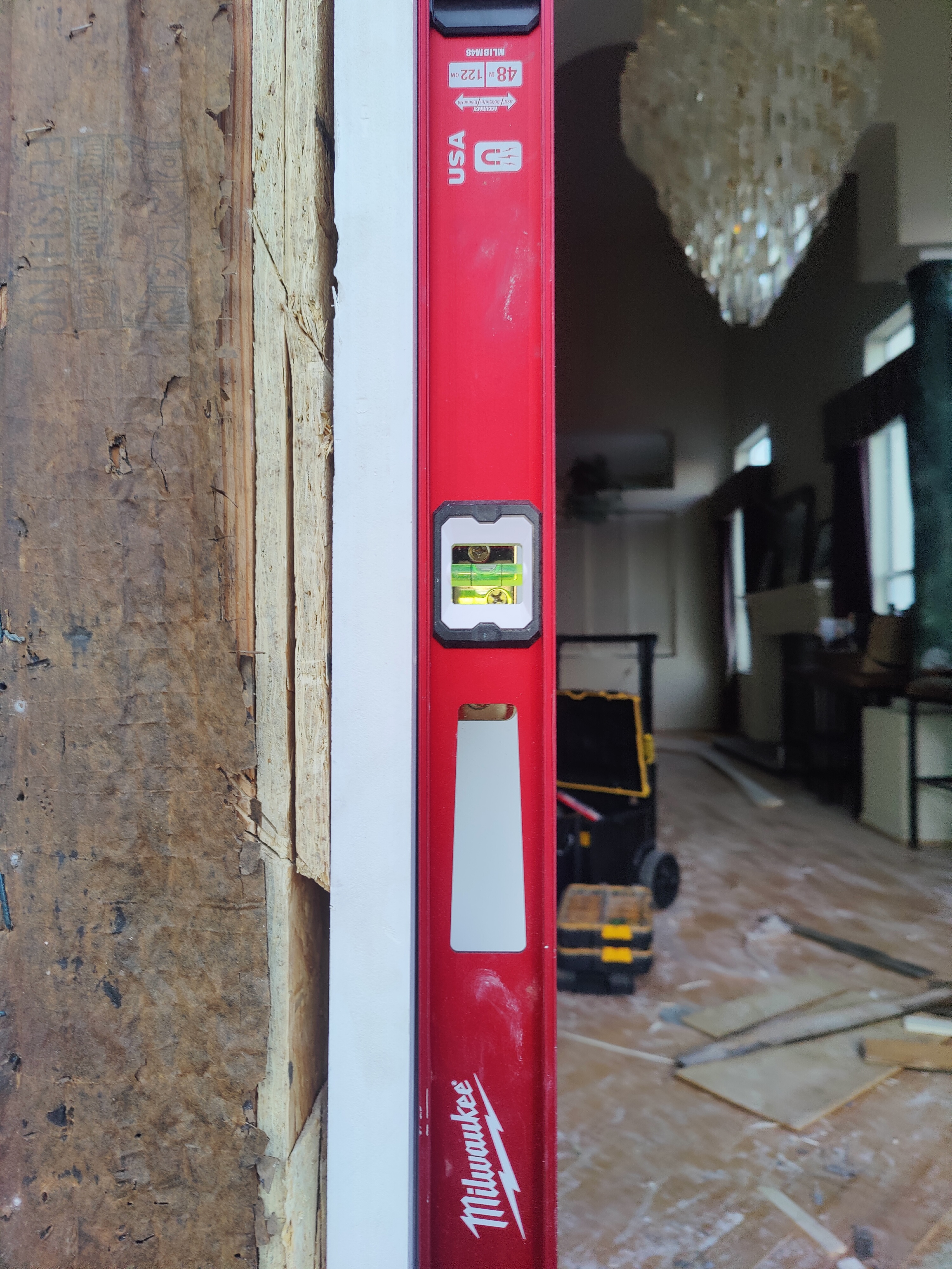 Verifying door jamb is plumb with level tool during installation