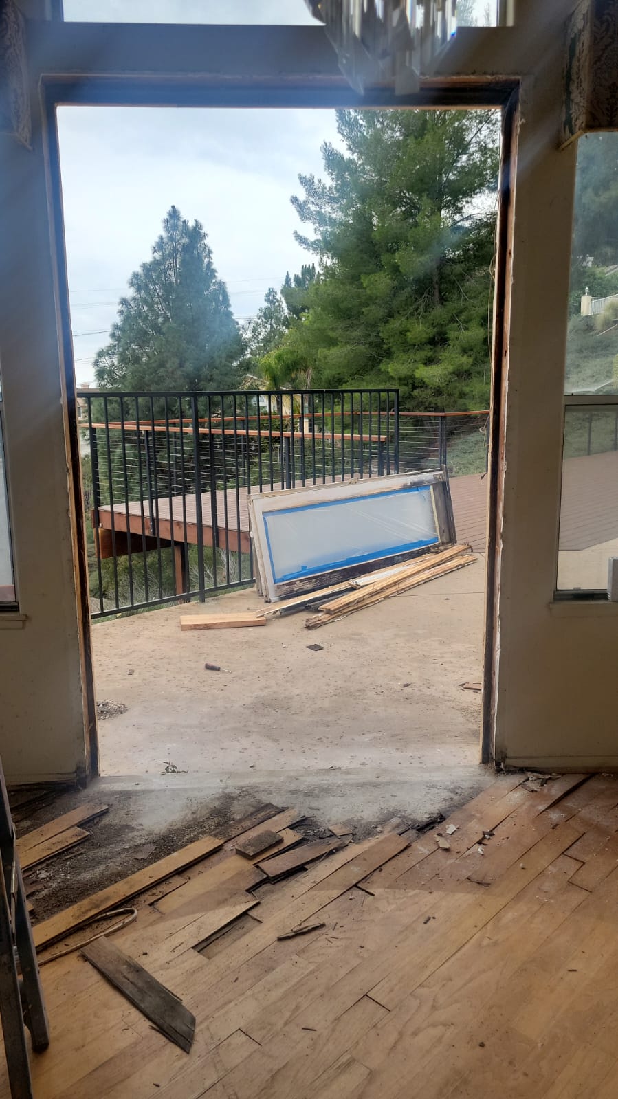 Old exterior door removed showing exposed frame and subfloor damage